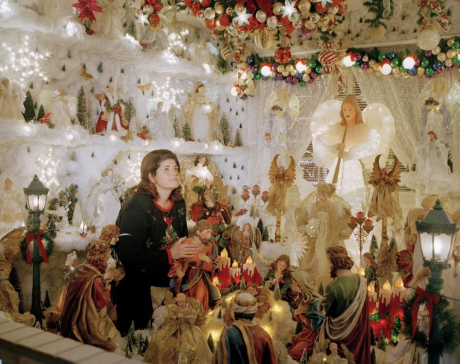 A woman sits in a room full of christmas decorations