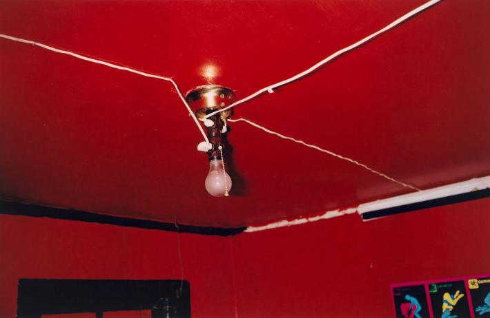 William Eggleston photograph of a bare lightbulb on a red ceiling in a red room