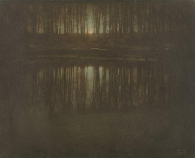 Edward Steichen photograph of a pond at night with the moon rising through trees behind it