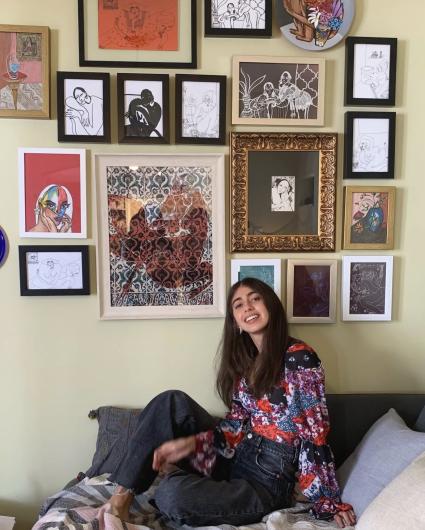 "Omani artist Mays Al Moosawi with some of her paintings."