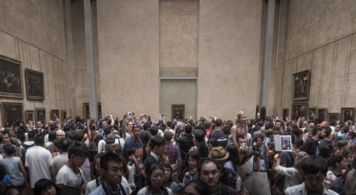 The Mona Lisa in the Louvre's Salle des États and protected by a purpose-built, climate-controlled enclosure topped with bulletproof glass. Photo by Joe Parks.