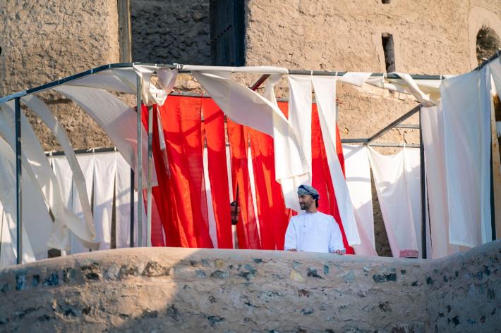 A guest standing by The Folding City by Safa Al Belushi in collaboration with Taher Majid, Rayan AlBalushi and Tara Atkinson. Image by Burair Alkishri for Sekka.