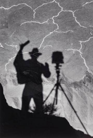 Ansel Adams black and white photograph of his shadow projected on the ground
