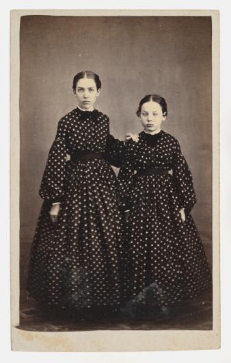 black and white photograph of two young women in black dresses