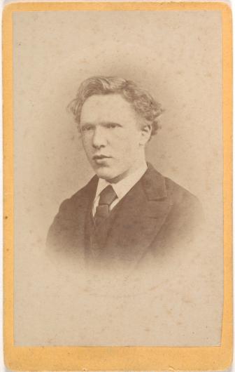 A circular, sepia photo of young vincent looking off into the distance. He is dressed in a suit and tie. 