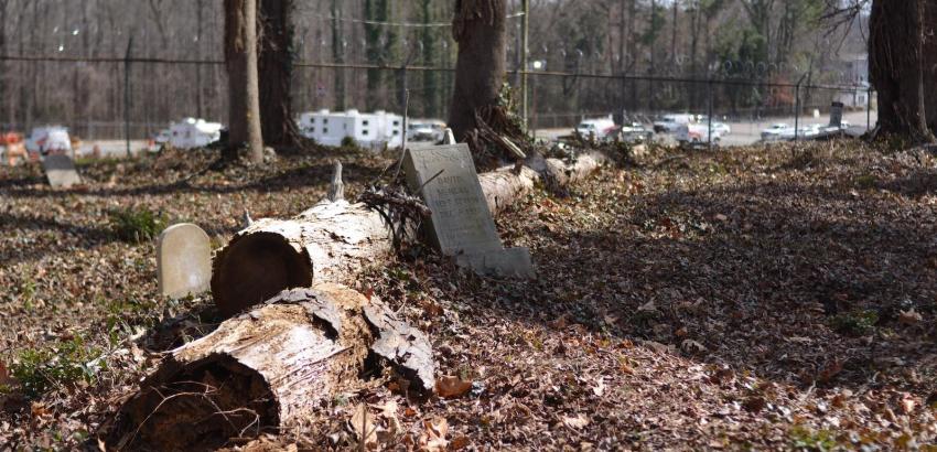 The backmost section of Geer cemetery is hedged in by a parking lot for a telephone company. Fallen trees are a common disruption in this portion of the cemetery and pose threats to the preservation of headstones.